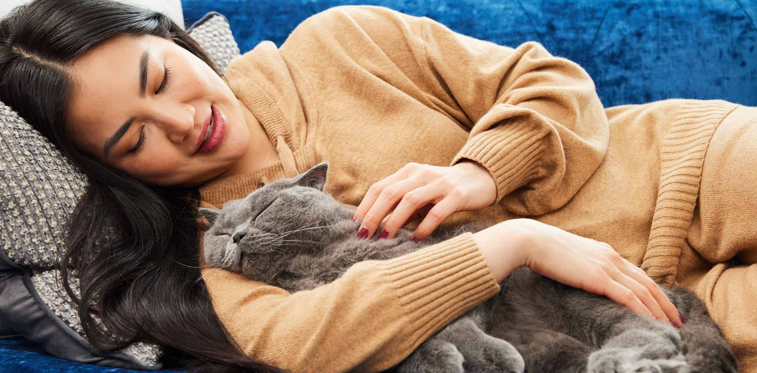 Prevention is the best medicine for a healthy pet (and a healthy wallet) - Woman resting on couch with her cat